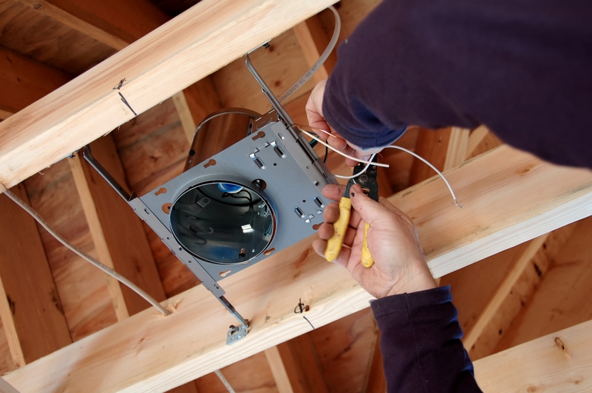 electrician installing light box in new home